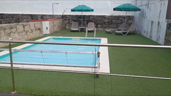 Espaço exterior de Alojamento Local com piscina e espreguiçadeiras